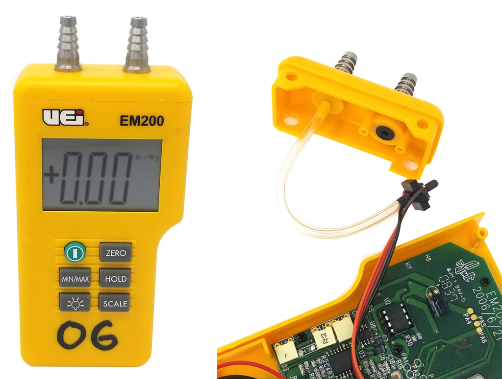 Image of a UEi EM200 digital manometer, with a close-up of the internal components showing the tubing and circuit board. The display reads +0.00 in-Wg, and the device has buttons labeled ZERO, MIN/MAX, HOLD, and SCALE. The cover is partially removed, exposing the internal connections.