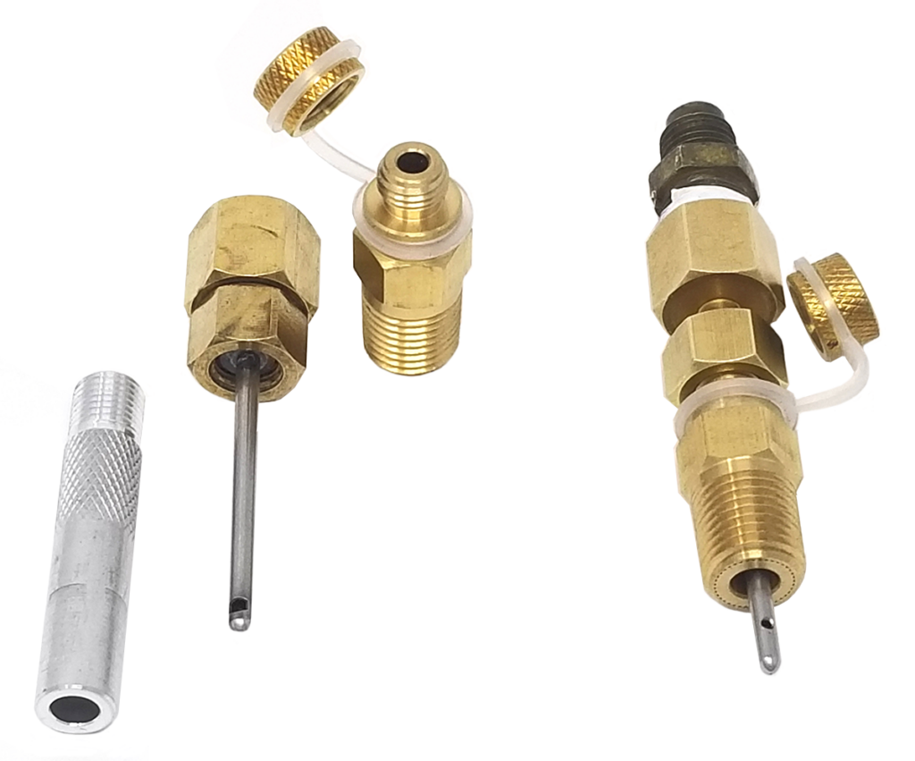 Three brass fittings arranged side by side, each with threaded ends and small metal probes extending from the center. The fittings have knurled caps attached by plastic loops, and are likely used for pressure or temperature measurement in HVAC systems. To the left of the fittings is a small metallic tool with a knurled grip, possibly for inserting or adjusting the probes.